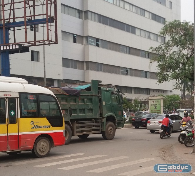 Mặc dù lực lượng chức năng đang xử lý vụ tai nạn nhưng xe quá tải vẫn ngang nhiên &quot;vượt rào&quot; tại ngã tư Phạm Hùng - Tôn Thất Thuyết.