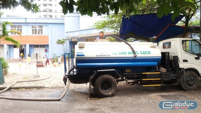 Xe chở nước do Công ty cổ phần Viwaco hỗ trợ cư dân tại tòa nhà 9B KĐT mới Đại Kim đang bơm nước vào bể cho dân. Ảnh Trần Việt.