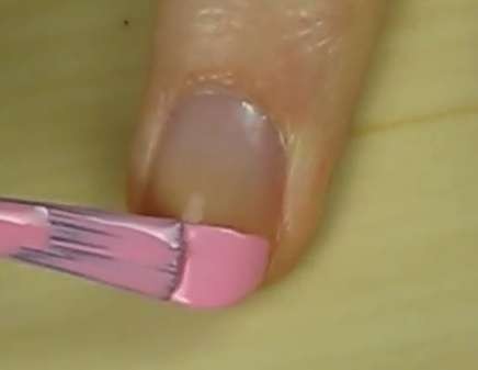 Bước 1: với ngón giữa, dùng sơn màu hồng phấn sơn phần đầu móng (khoảng 1/3 chiều dài của móng)