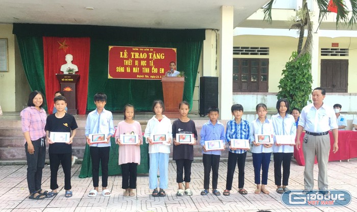 Đại diện Ban Giám hiệu cùng Hội phụ huynh Trường Trung học cơ sở Quỳnh Tân trao quà cho các học sinh có danh sách.
