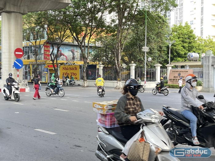 Một sinh viên băng qua đường Xuân Thủy, trước cổng Học viện Báo chí và Tuyên truyền.