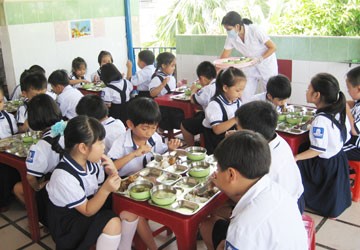 HS lớp 1 bán trú của Trường Tiểu học Kim Đồng đang ăn trưa tại trường. Trường đang lo lắng sẽ khó tổ chức cho HS bán trú như thế này trong năm học tới. Ảnh: PHẠM ANH