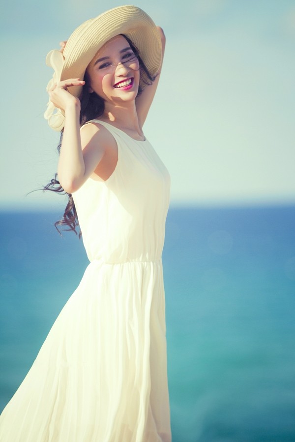 Váy trắng tinh khôi, tóc xõa ngang vai, Ngọc Diễm đầy ngọt ngào, dịu dàng trước biển xanh quê hương.(Theo Ngôi sao)