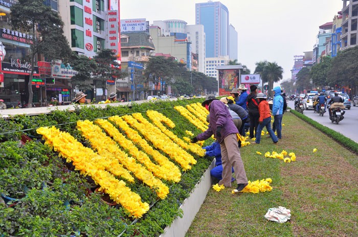 Nhân viên Công ty Vườn Thú Hà Nội chịu trách nhiệm dàn chữ hoa lụa tại các tuyến phố Nguyễn Chí Thanh, Trần Duy Hưng, Cầu Giấy, Láng Hạ - Thái Hà, Lê Văn Lương…
