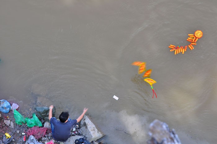 Một người dân tại chân cầu Long Biên còn thả cả một tràng pháo xuống sông