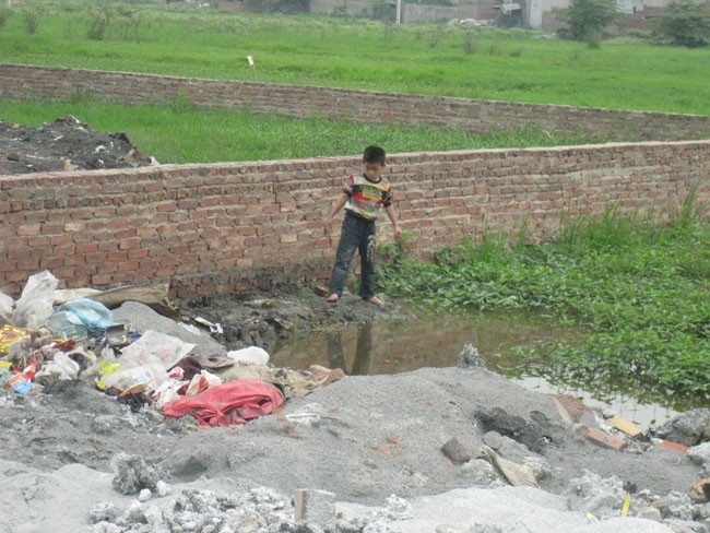 Trẻ em vô tư chơi đùa ở bãi rác phế thải bột nhôm mà không biết sự độc hại tới chết người của nó.