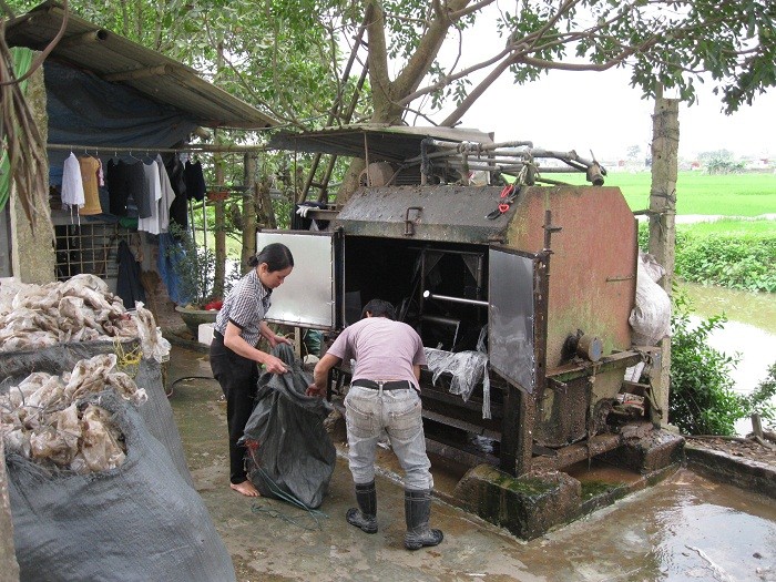 Một cỗ máy “giặt rác” chạy đinh tai nhức óc, xả nước bùn sền sệt đen kịt xuống kênh Tây Ninh. Những lao công “giặt rác” ướt nhách, chân đất, tay trần, cứ thế bốc nylon đen đúa bùn đất dòi bọ thả vào máy giặt ào ào.