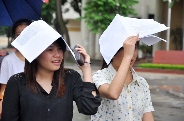 Sĩ tử kết thúc môn thi thứ 2, nhiều bạn lấy túi đựng giấy tờ để che mưa.