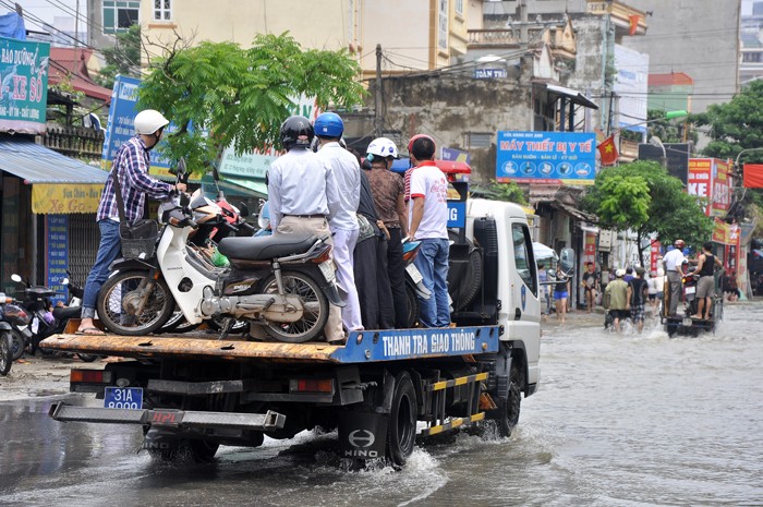 Xe cứu hộ của TTGTVT Hà Nội cùng xe của Cảnh sát quận, phường đã giúp người dân đi qua điểm ngập úng an toàn.