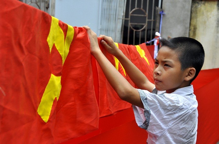Ngoài giờ đến trường, em Nguyễn Nam – con trai anh Phục thường về phụ giúp bố mẹ với việc phơi cờ, cuộn vải…