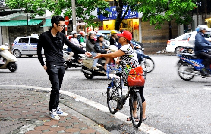 Trên một đoạn phố Bà Triệu, nhiều thanh niên đã bị người phụ nữ (trong ảnh) lừa cho tiền với lý do xin tiền để sửa xe đón con nhỏ.