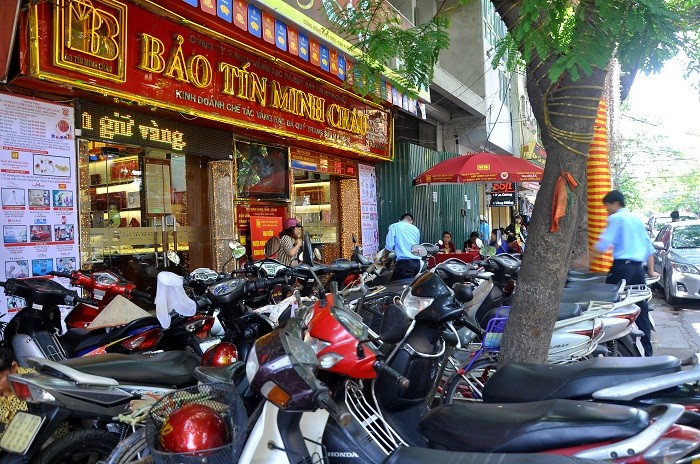Xe máy của khách đến giao dịch xếp chật kín trước cửa hàng vàng Bảo Tín Minh Châu.