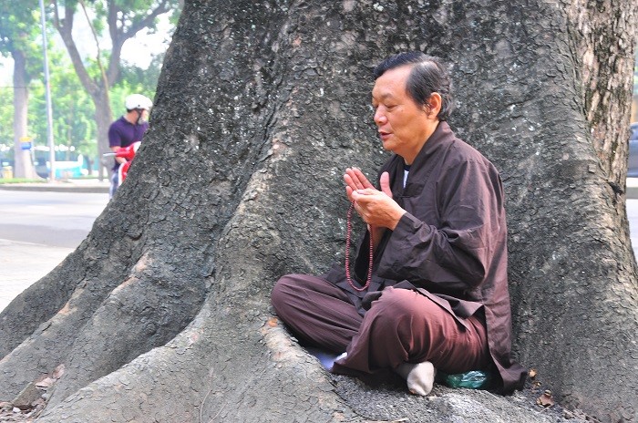 Một người dân ngồi tụng kinh tại một gốc cây trước nhà Đại tướng.