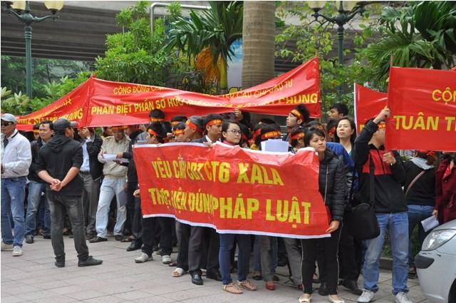 Người dân đeo băng rôn phản đối cách làm của chủ đầu tư Đại Thanh trước cổng Sàn giao dịch bất động sản Mường Thanh