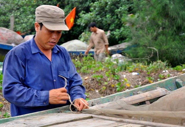 Anh Nguyễn Văn Hiện xã Hải Đông (Hải Hậu, Nam Định) đang nhanh chóng cột lại lưới trên thuyền.