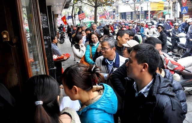 Tại một cửa hàng bán đồ thực phẩm trên Hàng Bông (Hoàn Kiếm, Hà Nội) nhiều người dân phải xếp hàng nửa tiếng đồng hồ mới mua được bánh.