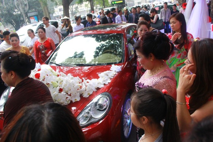 Chiếc xe được trang trí bằng hoa lan trắng và hoa hồng đỏ. Dọc phố Hàng Khay, giao thông ì trệ khi nhà trai chuẩn bị sang nhà gái đón dâu.