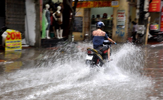 Trên phố Trần Bình (Cầu Giấy, Hà Nội), nước ngập tràn tới mép cửa nhà các hộ dân ven đường. Các phương tiện lưu thông qua đây gặp rất nhiều khó khăn.