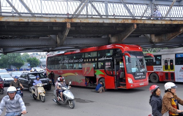 Chiếc xe khách giường nằm chất lượng cao bị kẹt trong gầm cầu Long Biên khiến giao thông qua đoạn này gặp nhiều khó khăn.