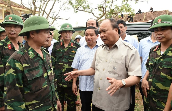 Thủ tướng Nguyễn Xuân Phúc trò chuyện với chiến sĩ lực lượng vũ trang đang tham gia khắc phục thiệt hại do bão số 10 gây ra (ảnh chinhphu.vn).