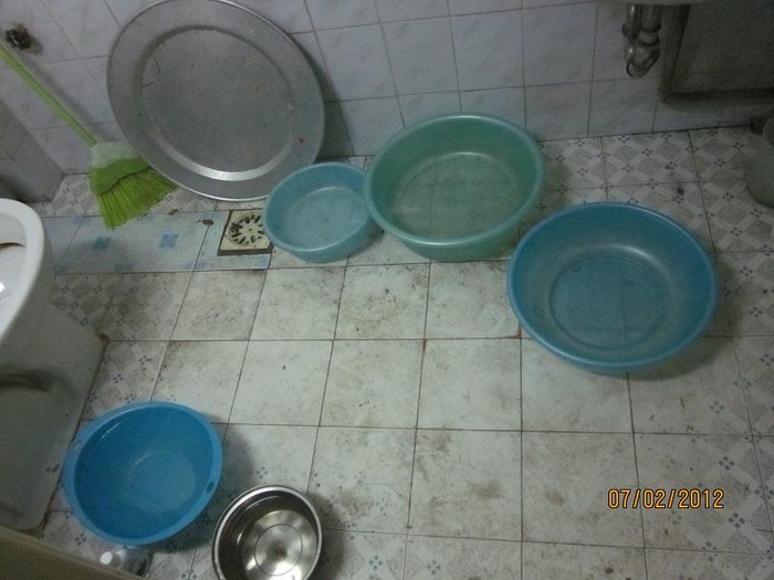 Đủ các xô, chậu được đưa ra đựng nước. Nền nhà tắm bẩn thỉu vì thiếu nước lau rửa.