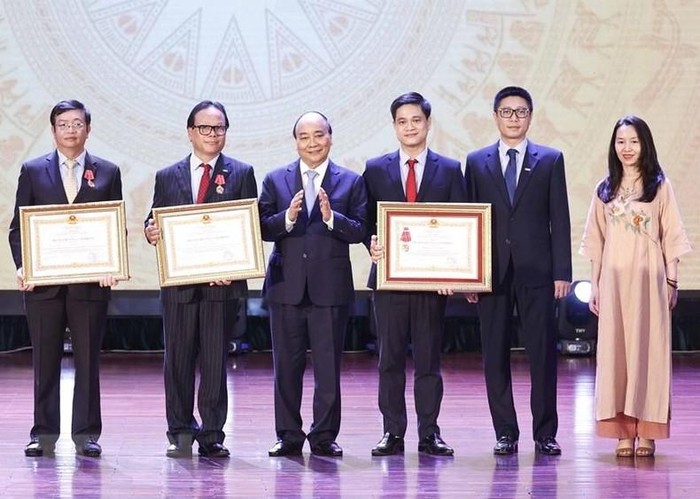 Chủ tịch nước Nguyễn Xuân Phúc trao tặng Huân chương Lao động hạng Ba cho tập thể và các nhân Trường Đại học Kinh tế Quốc dân. (Ảnh: Thống Nhất/TTXVN)