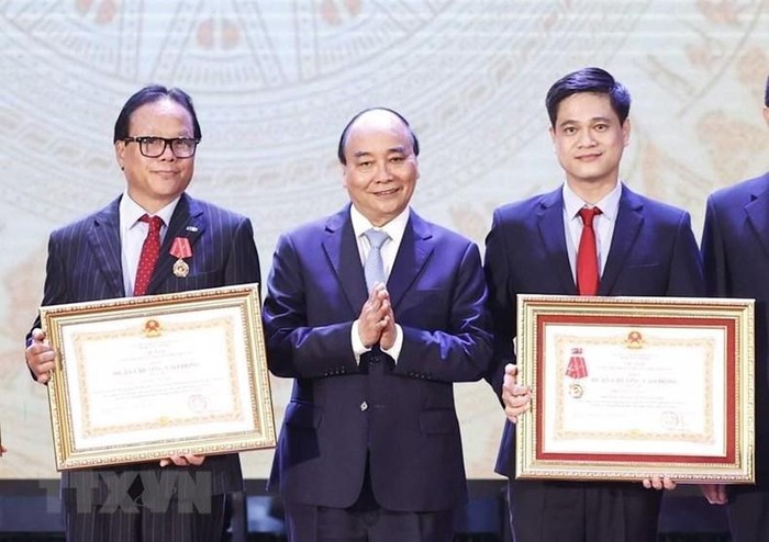 Chủ tịch nước Nguyễn Xuân Phúc trao tặng Huân chương Lao động hạng Ba cho tập thể và các nhân Trường đại học Kinh tế quốc dân. (Ảnh: Thống Nhất/TTXVN)