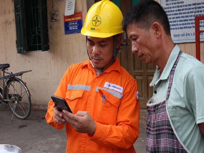 Công nhân Công ty Điện lực Lạng Sơn hướng dẫn khách hàng sử dụng dịch vụ điện lực trực tuyến thông qua nền tảng số