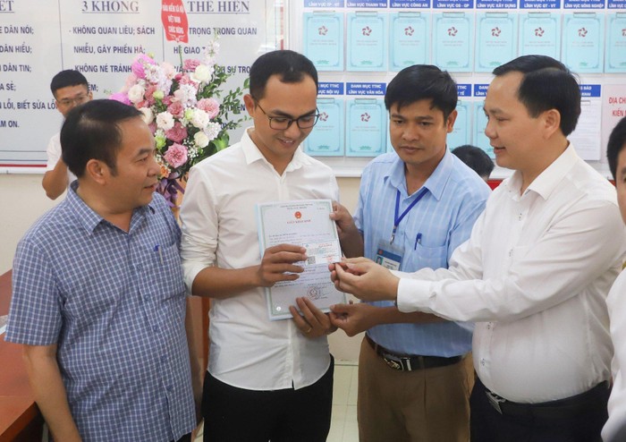 Phó Tổng Giám đốc Bảo hiểm xã hội Việt Nam Chu Mạnh Sinh trao thẻ bảo hiểm y tế cho trường hợp bé gái thực hiện đăng ký khai sinh, thường trú qua dịch vụ công liên thông