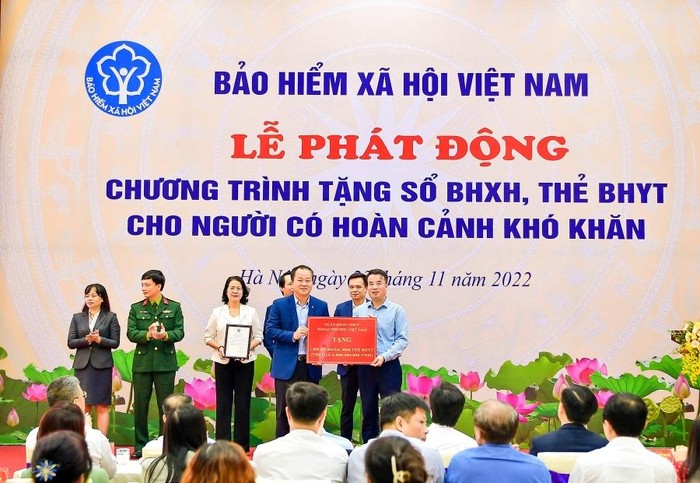 Phó Tổng Giám đốc Vietcombank Nguyễn Việt Cường (hàng đầu, bên trái) trao biểu trưng tặng 1.000 sổ bảo hiểm xã hội, 9.968 thẻ bảo hiểm y tế với tổng trị giá 5 tỷ đồng cho đại diện Bảo hiểm xã hội Việt Nam.