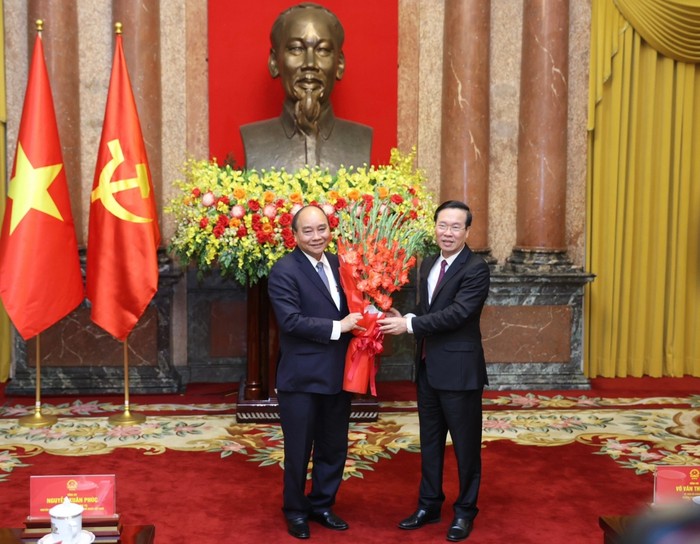 Thường trực Ban Bí thư Võ Văn Thưởng tặng hoa cho nguyên Chủ tịch nước Nguyễn Xuân Phúc.