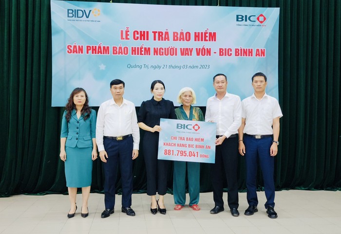 Đại diện lãnh đạo BIC và BIDV Quảng Trị trao tiền bảo hiểm cho khách hàng.