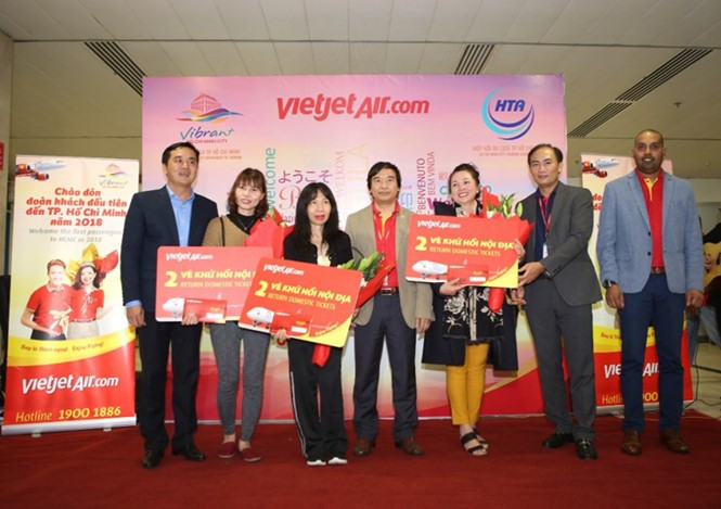 3 hành khách may mắn đầu tiên trên đi trên chuyến bay VJ173 chào năm mới 2018 được các lãnh đạo chào đón và nhận quà tặng là vé máy bay khứ hồi nội địa của Vietjet.