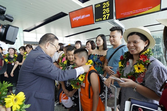 Phó Tổng giám đốc Vietjet Nguyễn Đức Tâm tặng hoa chào đón những hành khách đầu tiên.