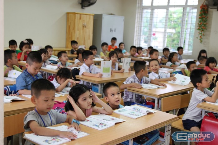 Lớp 1 Trường Tiểu học Chu Văn An, nhiều phòng học nhiều bàn có đến 3 học sinh ngồi học. Ảnh: Vũ Phương.