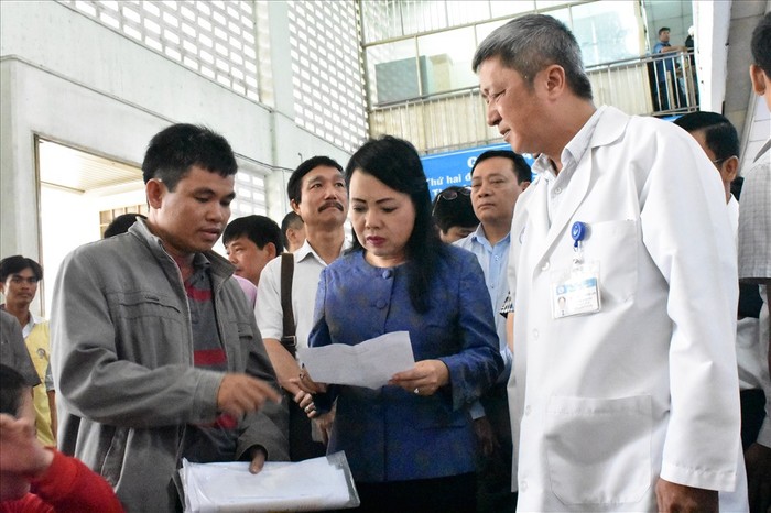 Bộ trưởng Nguyễn Thị Kim Tiến hỏi thăm sức khỏe của một người dân tới khám bệnh tại Bệnh viện đa khoa Hoài Đức, Thành phố Hà Nội. Ảnh: Infonet.
