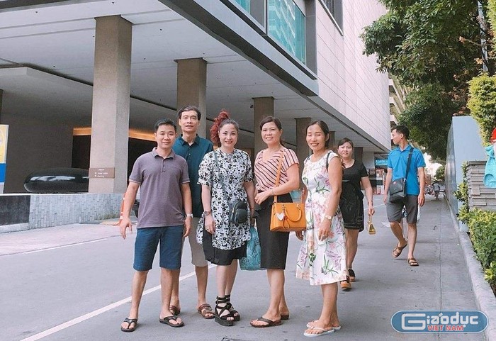 Bà Hương chụp ảnh cùng ông Huân, Phó trưởng Phòng Giáo dục và đào tạo huyện Thuận Thành (thứ 2 từ trái sang) và thầy cô giáo trong chuyến tham quan. Ảnh: NVCC.