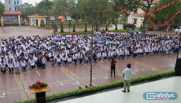 Hơn 1.500 học sinh đội mưa chăm chú lắng nghe Giáo sư Nguyễn Lân Dũng nói về cuộc cách mạng công nghiệp 4.0 qua những câu chuyện cảm động, truyền cảm hứng mạnh đến học sinh bằng những tràng pháo tay. Ảnh: Vũ Phương.