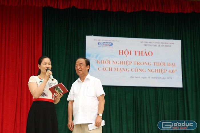 Giáo sư Nguyễn Lân Dũng tặng sách cho giáo viên. Ảnh: Vũ Phương.
