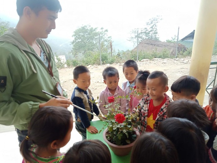 Một giờ hoạt động ngoài trời, thầy Công giới thiệu cho các em về các loài hoa để các em biết yêu thiên nhiên, bảo vệ môi trường. Ảnh: NVCC.