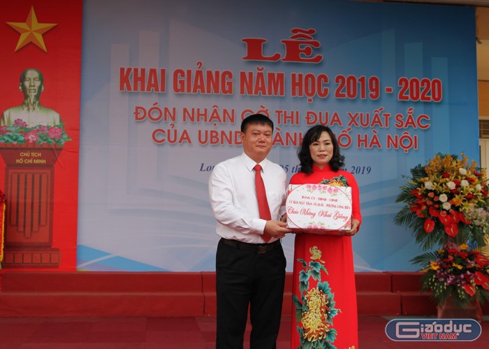 Cô Đồng Thị Quyên nhận quà từ đại diện Ủy ban nhân dân phường Long Biên dành tặng cho những học sinh có khoàn cảnh khó khăn. Ảnh: Vũ Phương.