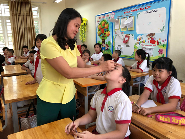 Để đảm bảo, giữ gìn sức khỏe cho học sinh, giáo viên chủ nhiệm tiến hành nhỏ mắt, mũi bằng nước muối Natri clorid 0,9% cho 100% học sinh toàn trường. Ảnh: Tiểu học Hạ Đình.