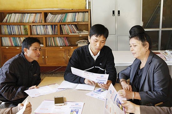 Nhân viên đại lý thu điểm Bưu điện văn hóa xã Yên Hưng (Sông Mã) tuyên truyền chính sách BHXH tự nguyện cho người dân.