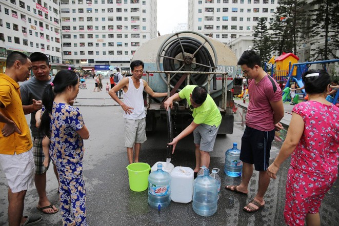 Nhiều người dân Hà Nội khốn khổ vì nước sạch Sông Đà nhiễm bẩn vẫn bơm bán cho người dân. Ảnh: TTXVN.