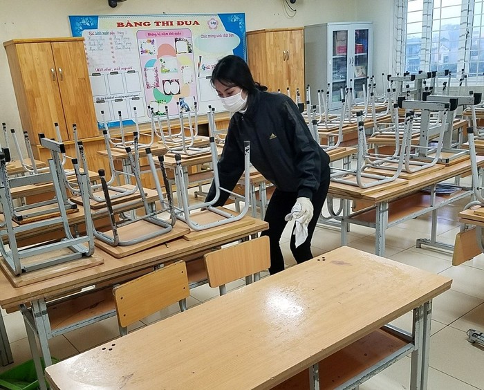 Giáo viên Trường Tiểu học Chu Văn An (Hoàng Mai) làm công tác vệ sinh bàn ghế, phòng học phòng tránh dịch Corona để sãn sàng đón học sinh trở lại trường. Ảnh: TH Chu Văn An.