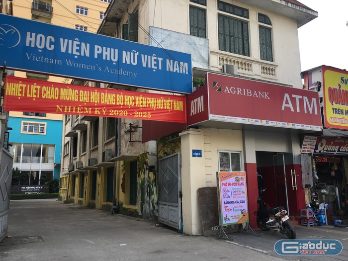 Cổng B của Học viện Phụ nữ Việt Nam lọt thỏm giữa những hàng quán thuê mặt bằng của Học viện. Ảnh: Vũ Phương.