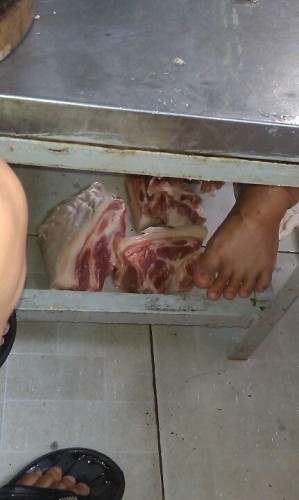 Thịt để ngay dưới chân của nhân viên nhà bếp, mất vệ sinh kinh khủng.