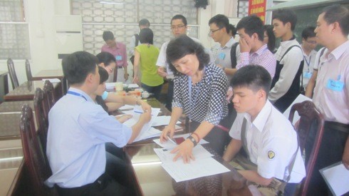 Thí sinh điều chỉnh giấy tờ thi tại phòng hội đồng của điểm thi THPT Hoàng Hoa Thám (ảnh: Thế Quân)
