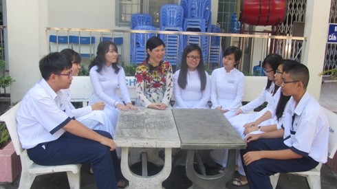 Ngoài giờ học trên lớp, cô Lê Kim Mai(người mặc áo dài hoa, ở giữa) luôn gần gũi, chia sẻ mọi quan điểm về bài giảng với học sinh (ảnh: T.Q)