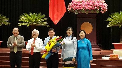 Tân Chủ tịch UBND TP.HCM Nguyễn Thành Phong (cầm hoa) nhận hoa chúc mừng của lãnh đạo HĐND TP.HCM (ảnh: T.Q)